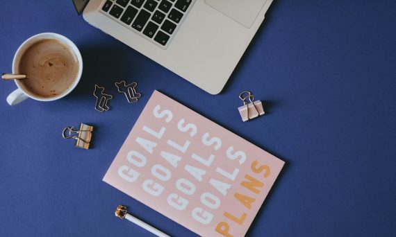 Pink planner on blue background with gold stationery and laptop ✦ Snag more FREE stock photos each month 👉 https://contentpixie.com/secret-snaps/
